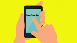 Fundo amarelo com a figura de uma mão apontando para um celular onde está escrito: SouGov.br